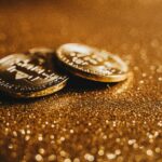 Golden Bitcoin coins on a glittery background symbolizing digital currency wealth.